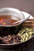 A cup of chai tea with spices on the saucer