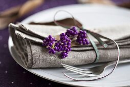 A place setting with a napkin and beautyberries