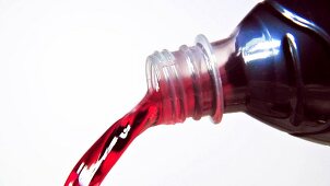 Pouring grape juice out of a bottle