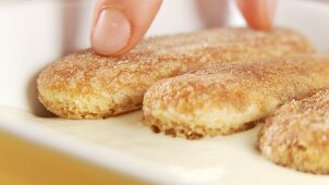 Preparing tiramisu: adding another layer of espresso biscuits