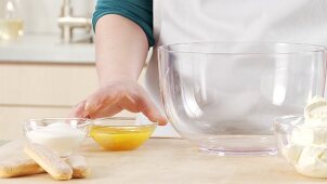 Preparing tiramisu: placing the egg yolks in a bowl