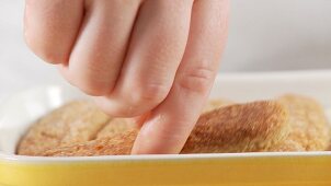 Preparing tiramisu: adding another layer of sponge fingers
