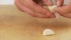 Garlic being peeled and chopped