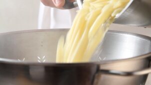 Cooked pasta being drained