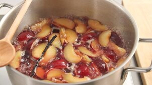Plums being turned into syrup with a vanilla pod