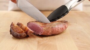 Slicing fried duck breast