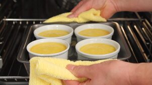 Creme caramel being removed from the oven