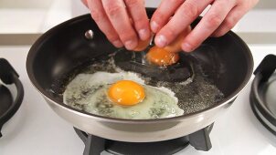 Eggs being cracked into a pan