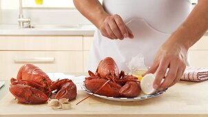 Cooked lobster being served with butter and lemon