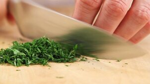 Dill and parsley being chopped