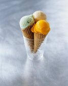 Three ice cream cones with various ice cream flavours