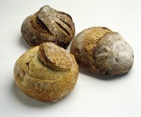 Drei verschiedene runde knusprige Brotlaibe