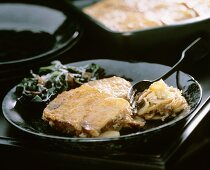 Kartoffelgratin mit Salat auf Teller mit Gabel