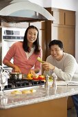 Young couple chopping vegetables in kitchen