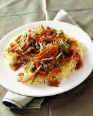 Strips of beef and strips of red pepper on noodles