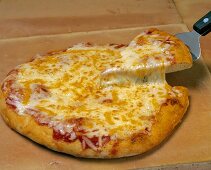 Cheese Pizza with a Piece Being Taken Out