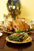 Roast Turkey on a Platter with Platter of Asparagus on Thanksgiving Table