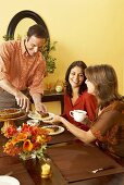 Man Serving Pie to Women at Thanksgiving Table