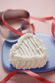 Heart Shaped Cupcake with Vanilla Frosting on a Plate with Pink Ribbon