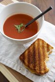 Partially Eaten Grilled Cheese Sandwich with a Bowl of Tomato Soup
