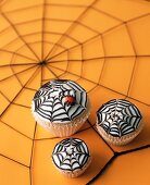 Three Spider Web Cupcakes on Spiderweb Table Top for Halloween