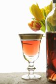 Roseweinglas und Flasche vor Tulpenstrauss