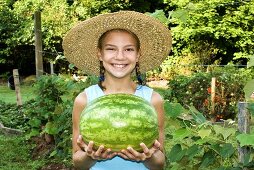 Young Girl Holding a Freshly Picked Watermelon; In Garden