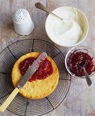 Spreading Strawberry Preserves Over Sponge Cake; Cream