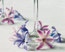 Pink and purple flowers arranged around the base of a glass