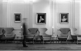 A spacious hallway with winged armchairs and tables from the 1950s