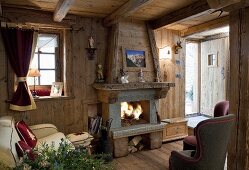 A cosy living room with a fireplace in a wooden hut
