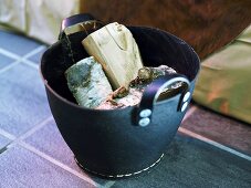 Firewood in a black leather basket