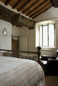 Rustic bedroom under a wooden timber beam ceiling