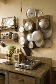 Gas stove on a rustic wooden working area and cooking utensils hanging on a wooden board