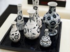 Collection of vases with a black-and-white design on a black tray