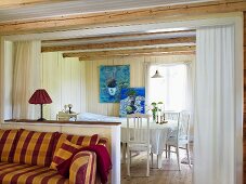 An open-plan living room-cum-dining room with white wood panelling