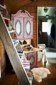 A wooden ladder against a wall and a country-style corner cupboard in a wooden house