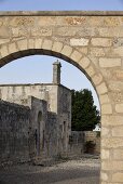 Blick durch alten geziegelten Torbogen auf italienische Kirche