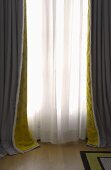 Window with gray and white floor length curtains