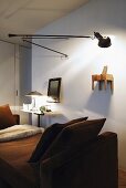 Lounger in front of a room divider with adjustable wall lamp