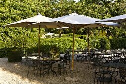 Sonnenstimmung auf Terrasse eines Restaurants mit Gartenmöbeln und Sonnenschirm