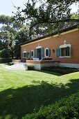 Mediterranean villa with a red brick facade and terrace in a manicured garden