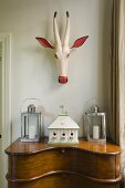 A painted wooden antelope head hanging above a Biedermeier-style davenport