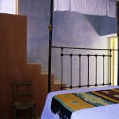Mediterraner Schlafraum mit blauer Wand und Treppenaufgang