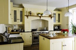 A light yellow kitchen in an English country house with an island counter