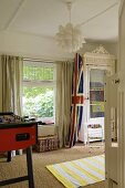 A boy's bedroom - a Union flag on a surf board next to a window with a view