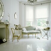 An elegant living room with a bay window and Rococo style chairs on a white painted floor
