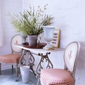 A small table with plants and two chairs in a 19th century German thatched-roof house decorated in a Scandinavian style