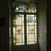 Antique stained glass window on a terrace door with shutters