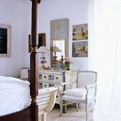 A bedroom with antique, white-painted country house-style furniture